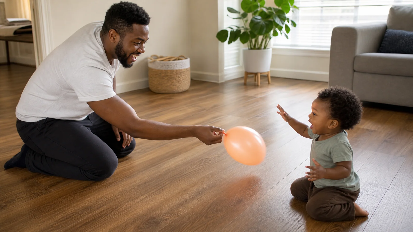 A grown-up sits face to face with a toddler while holding an inflated balloon and waiting for the word go.