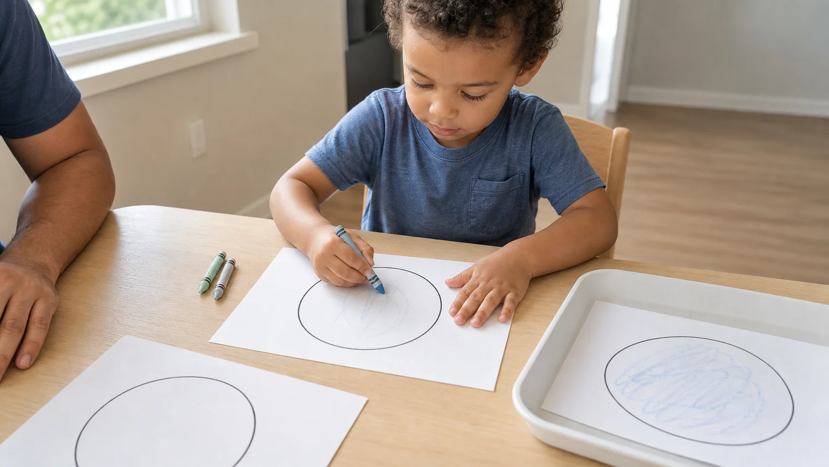 Toddler coloring a simple shape with a pale crayon at a quiet table with a done tray nearby