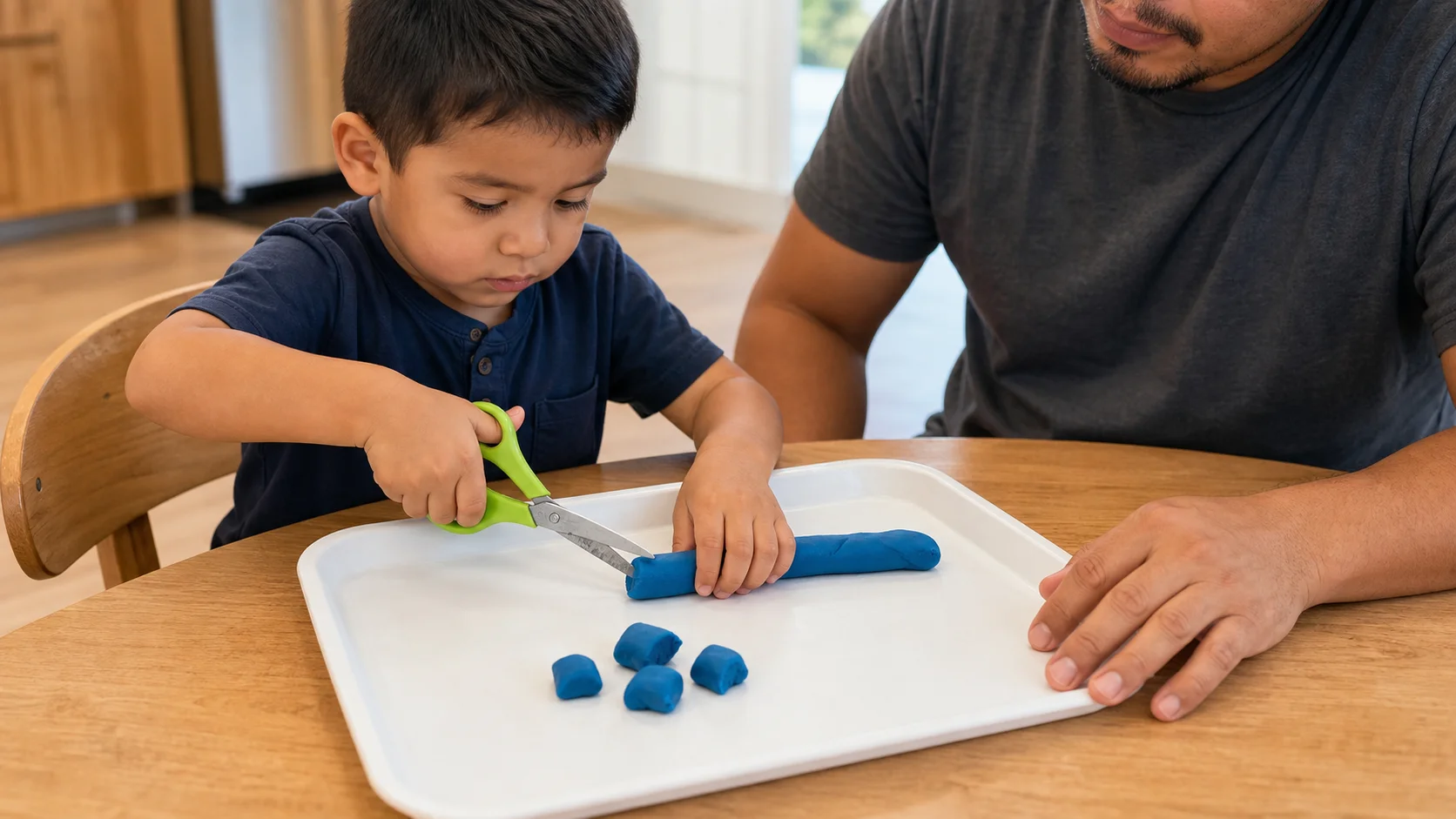A child using child-safe scissors to snip a playdough snake on a tray.