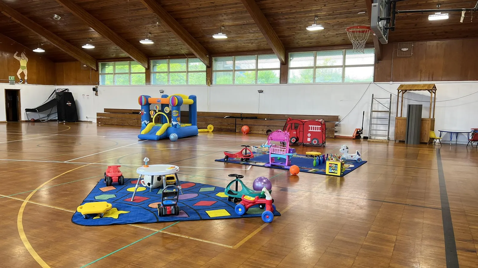 Toddlers riding trikes in a rec center gym