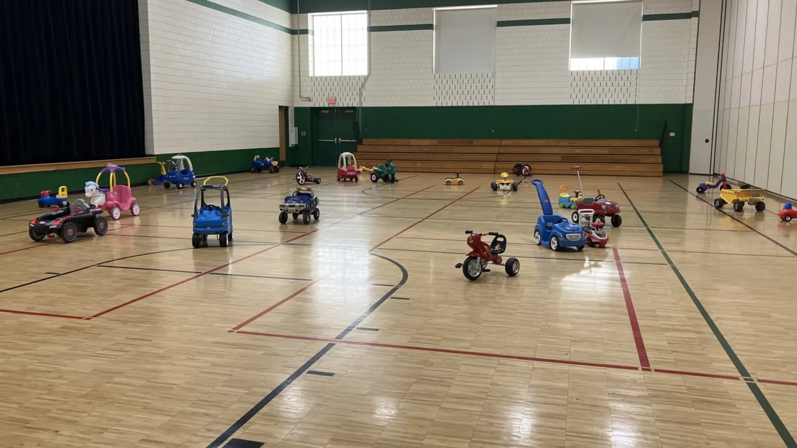 Toddlers playing on ride-on toys at Crystal Community Center