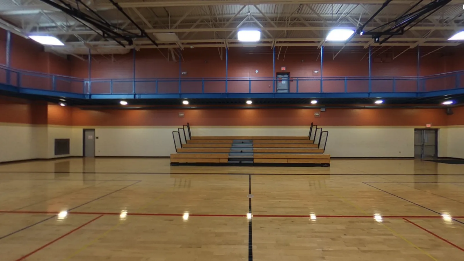 Kids riding scooters and playing with balls in a large gym