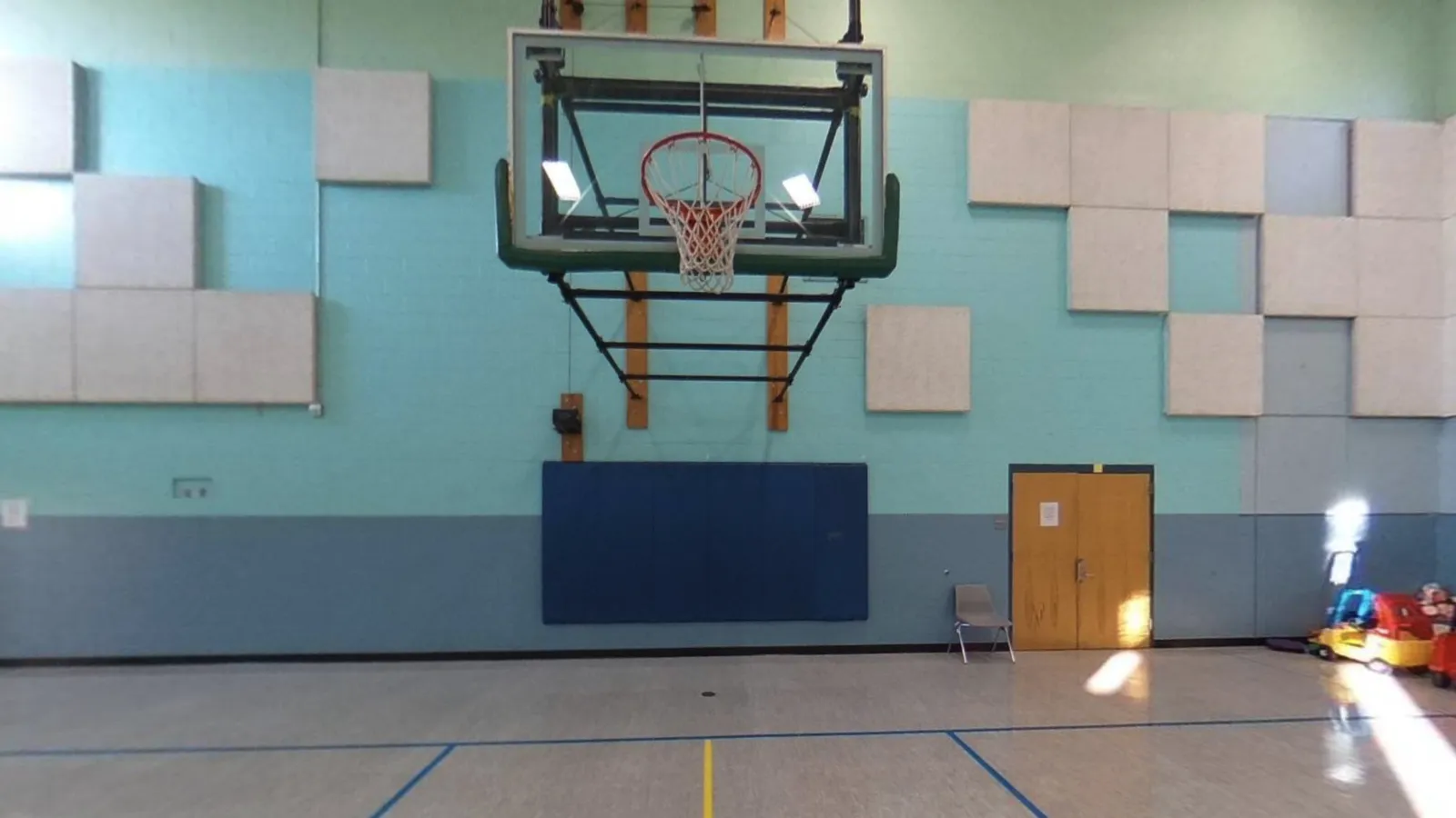 Children playing with tunnels and ride-ons in a gym