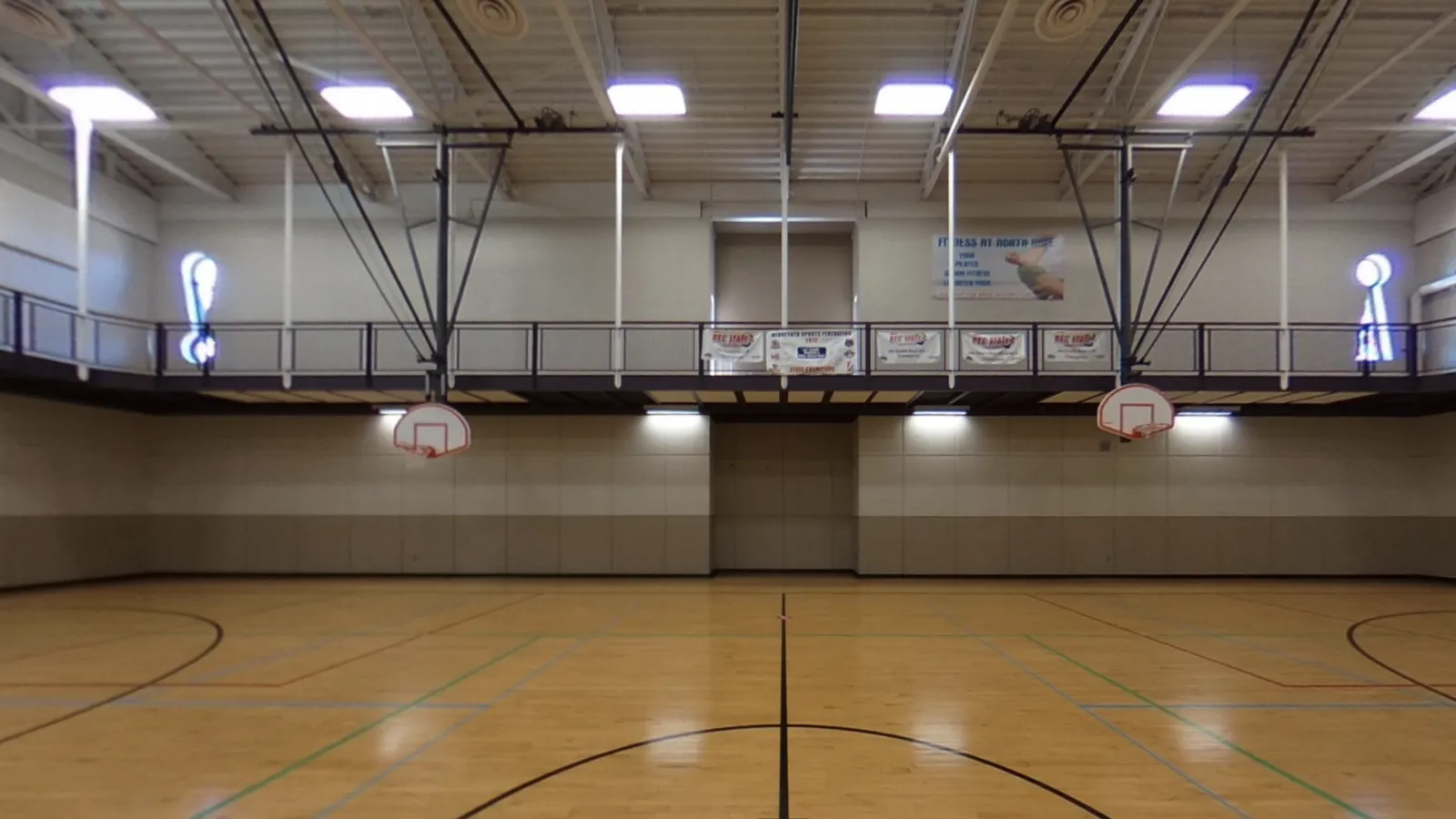 Kids playing with ride-ons and balls in a gym
